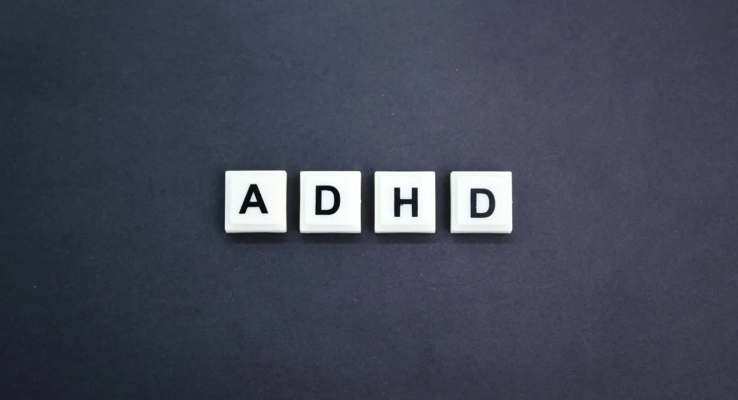 ADHD Paralysis concept with letter blocks spelling ADHD on dark background