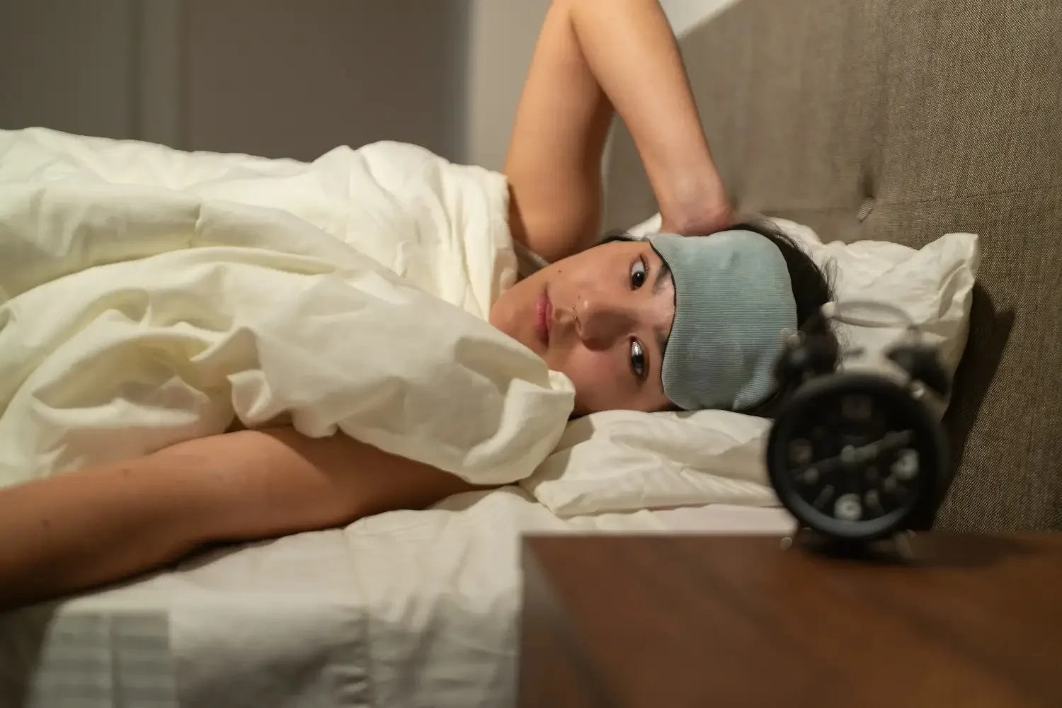Person lying awake in bed at night struggling with insomnia and sleep disturbance related to insomnia Treatment Manhattan care.