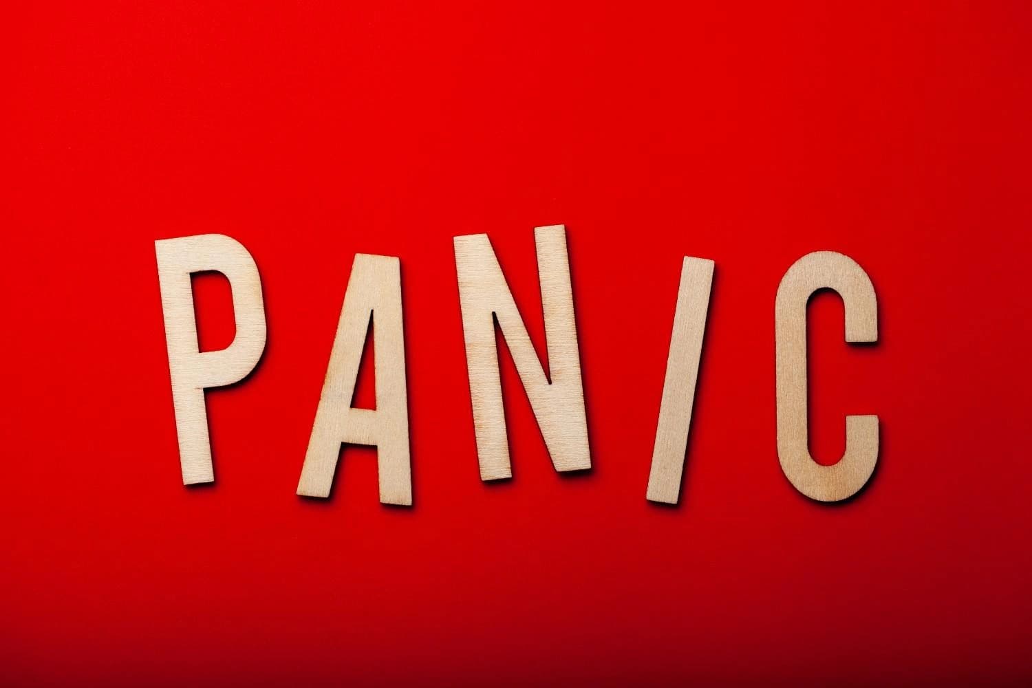 How to Avoid Panic – wooden letters spelling “PANIC” on a red background, representing techniques and tips to manage anxiety and prevent panic attacks.