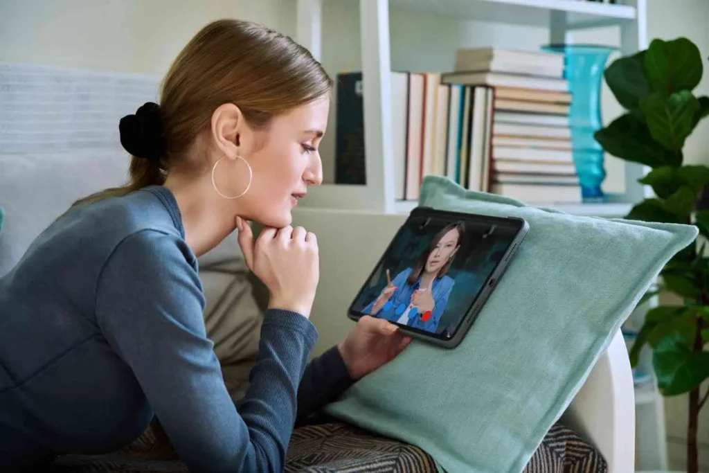 Woman using tablet for Online PTSD Treatment session at home with therapist video call