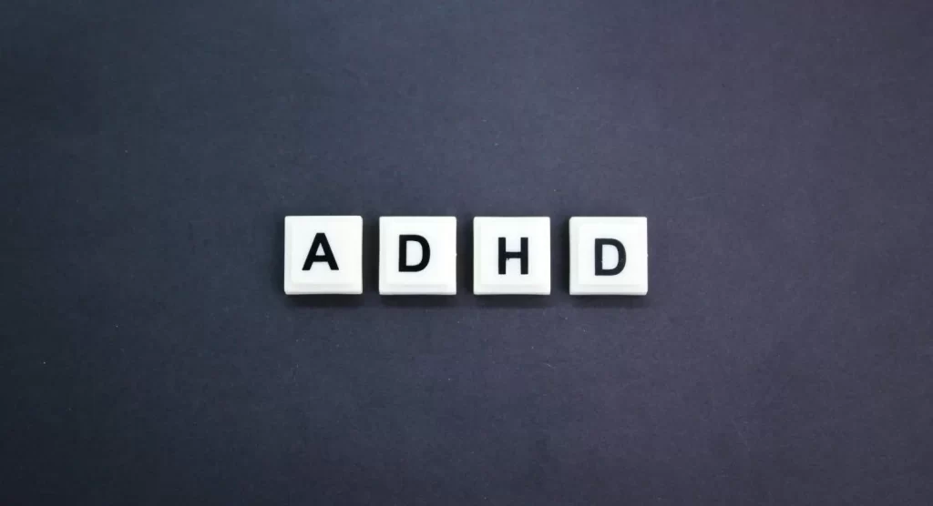 ADHD Paralysis concept with letter blocks spelling ADHD on dark background
